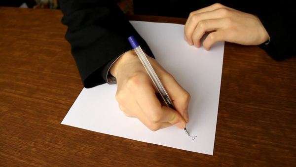 man writing on a piece of paper